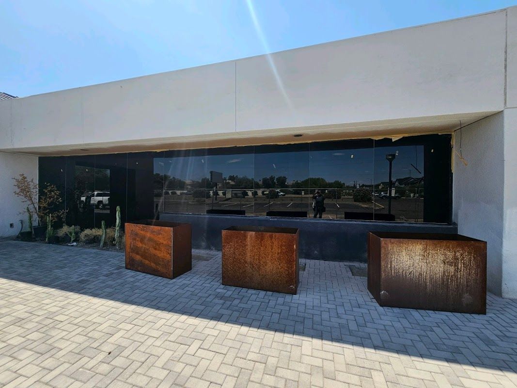 A large building with a lot of windows and planters in front of it.