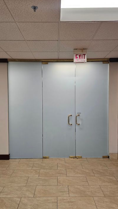 A large glass door with a red exit sign above it