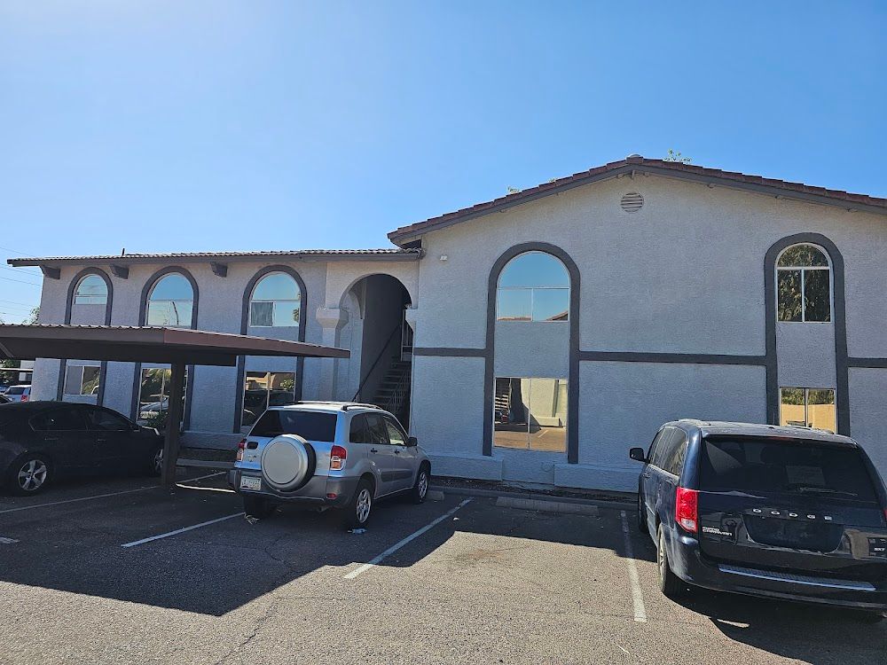 A white building with cars parked in front of it.