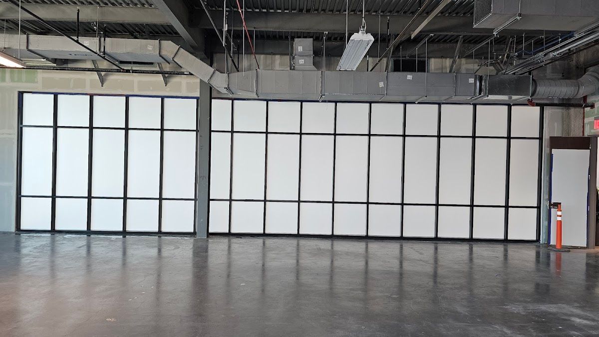 A large empty room with a lot of windows and a door.