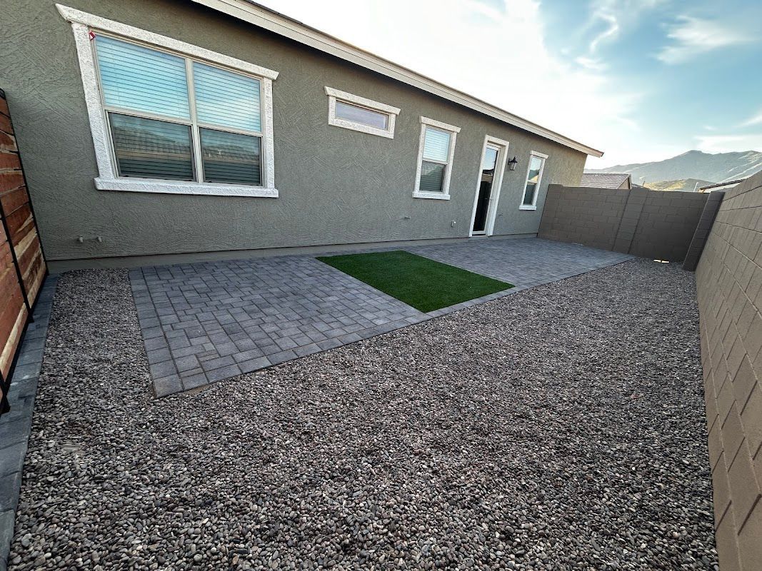The backyard of a house with a patio and grass.