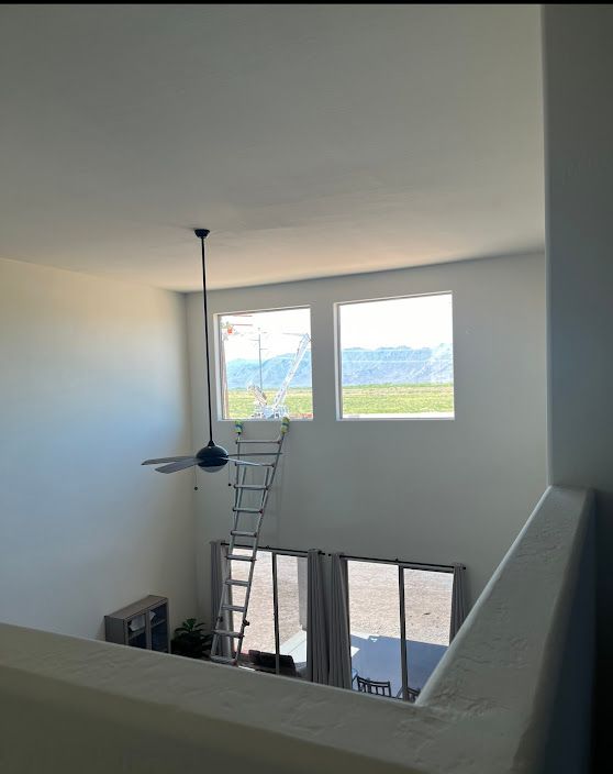 A room with a ladder and a ceiling fan