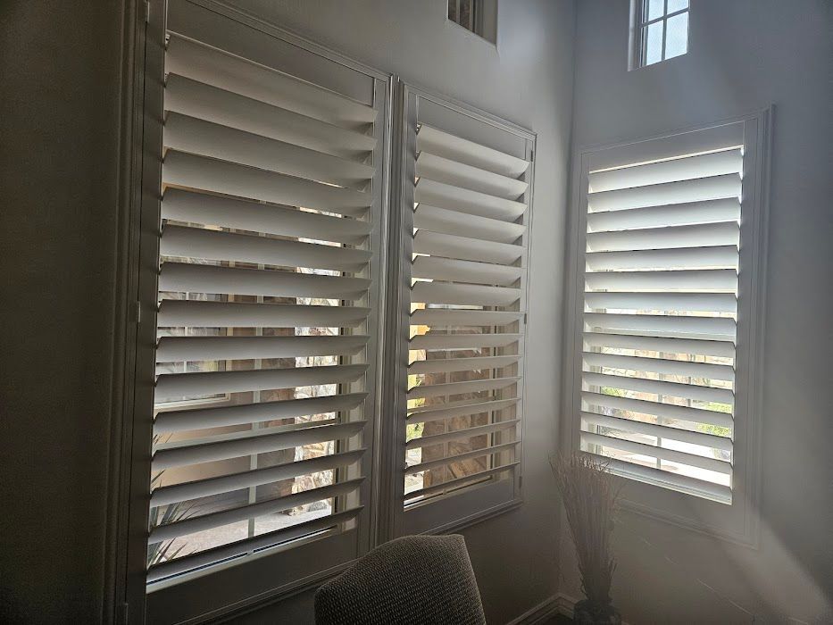 The sun is shining through the shutters of a window.