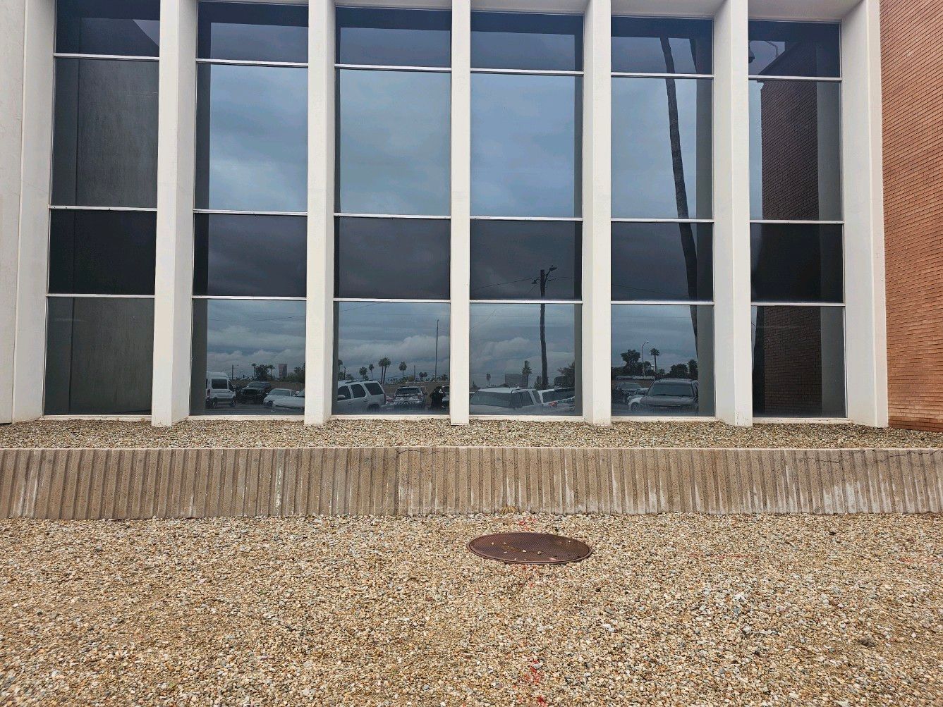 A building with a lot of windows and a manhole cover