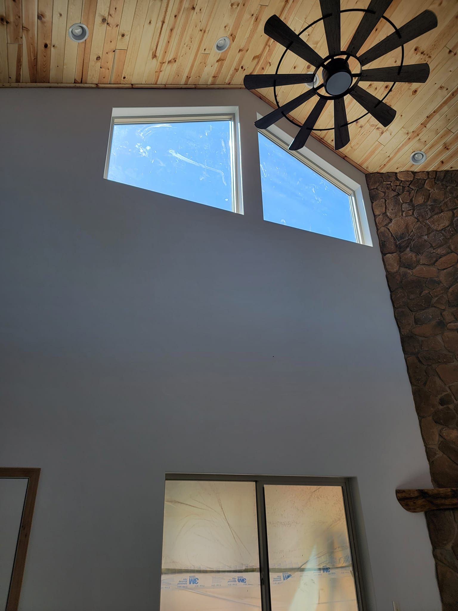 A ceiling fan is hanging from the ceiling above a window.