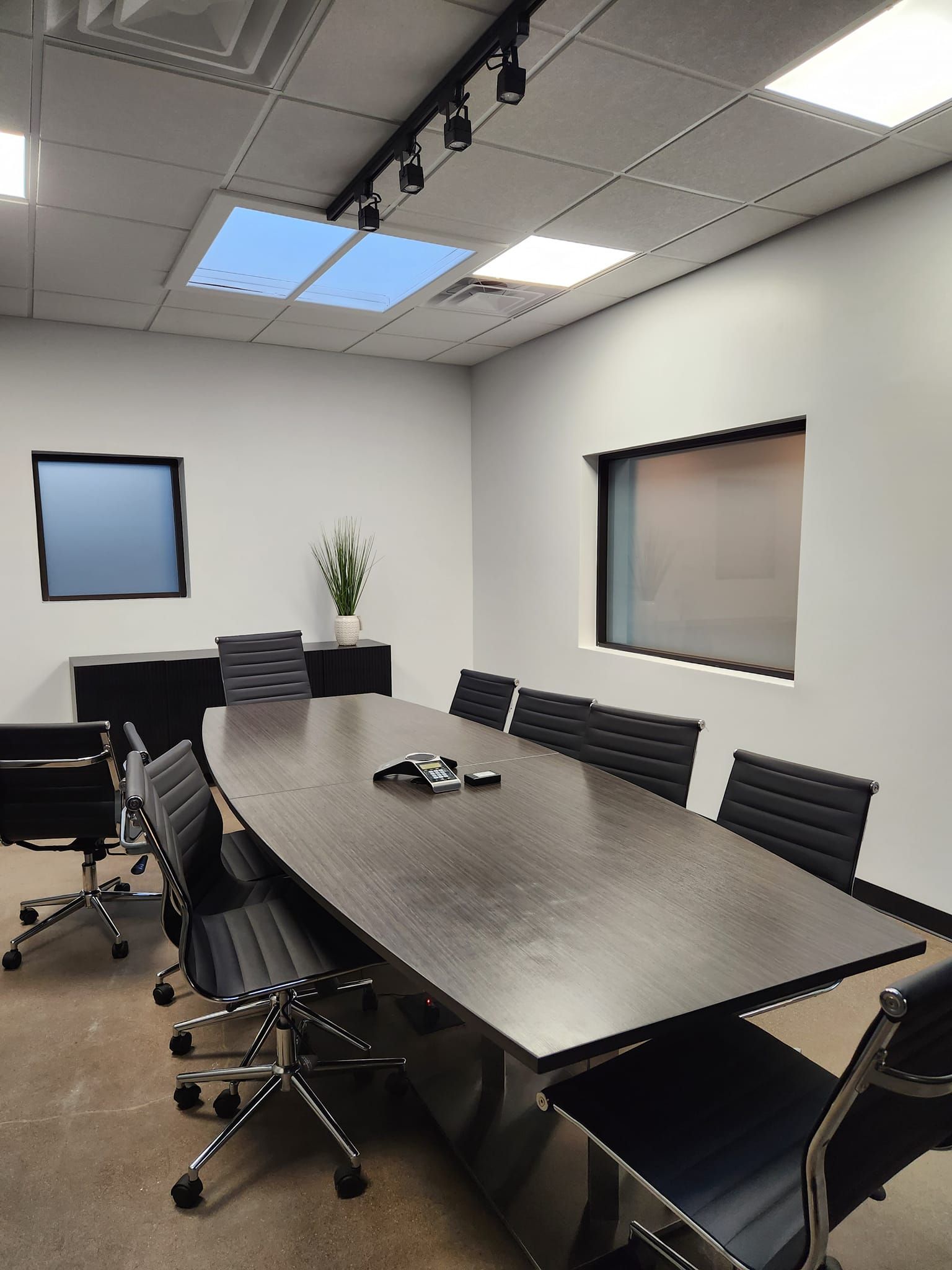 A conference room with a long table and chairs.