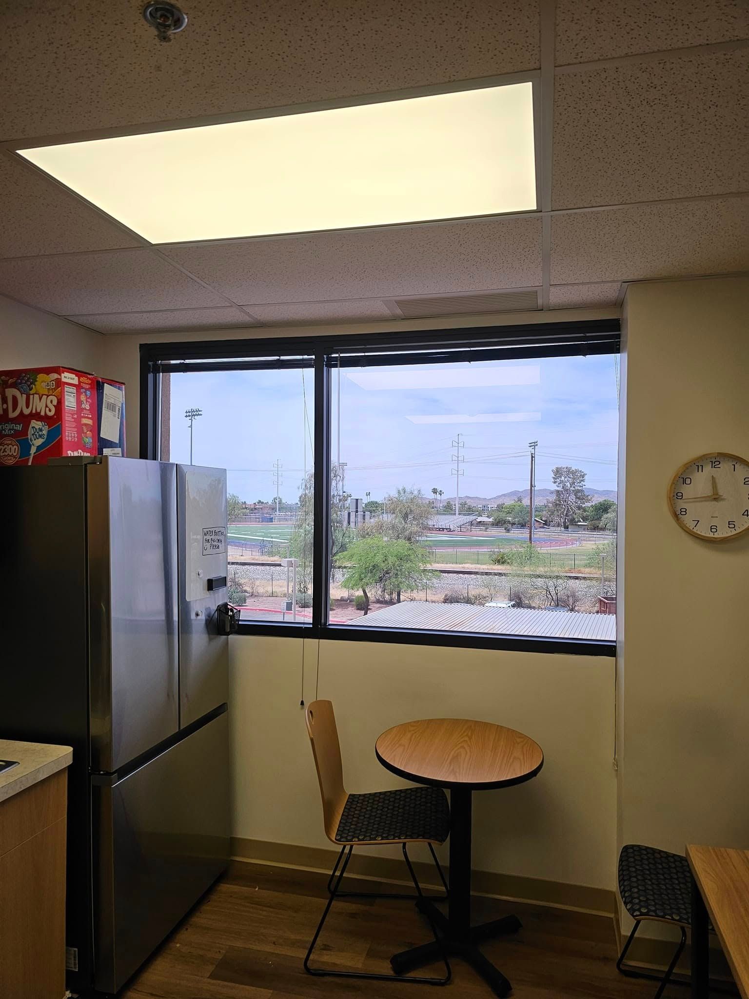 A kitchen with a table and chairs and a clock on the wall