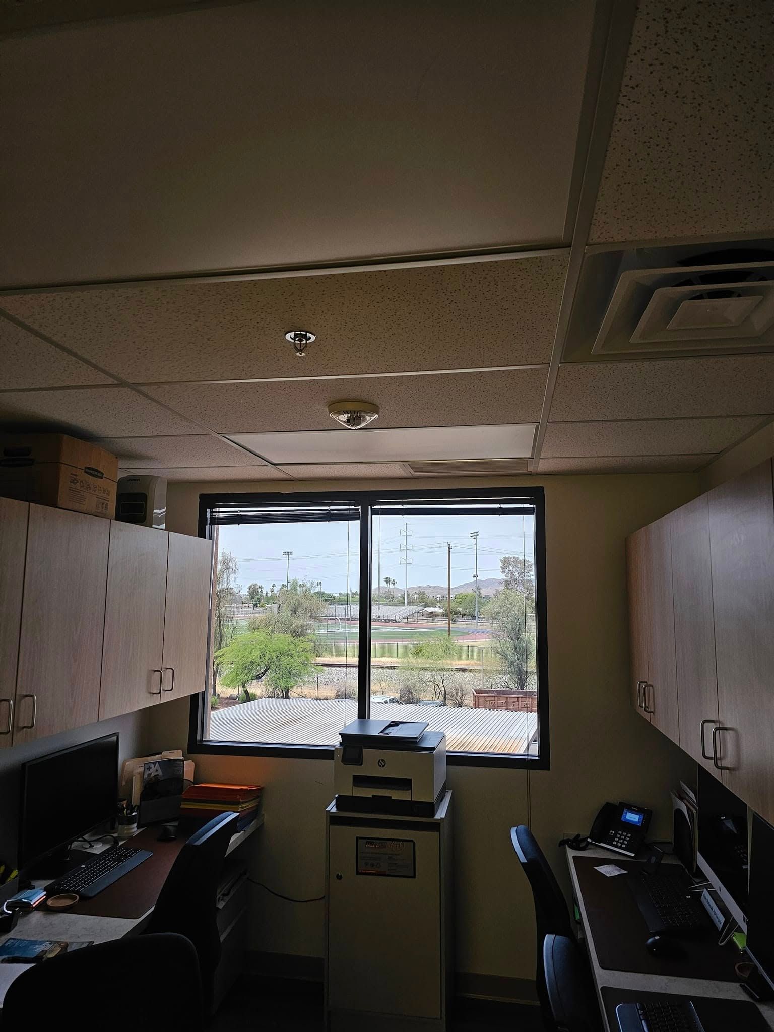 A small office with a printer and a window