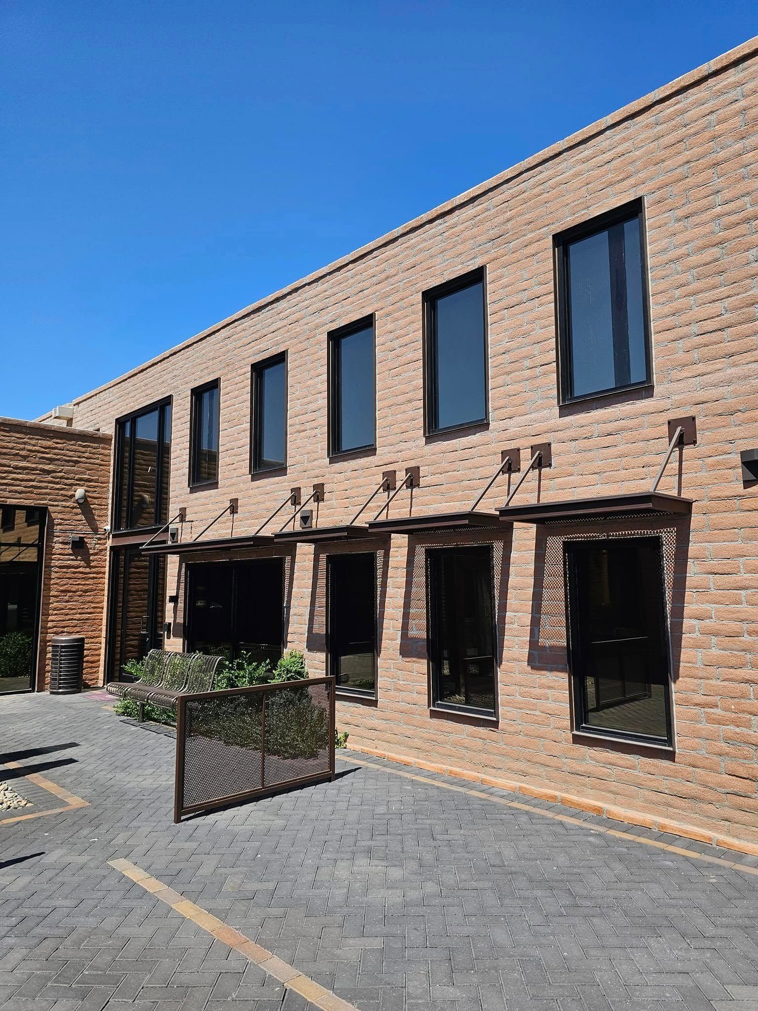 A large brick building with a lot of windows and a parking lot in front of it.
