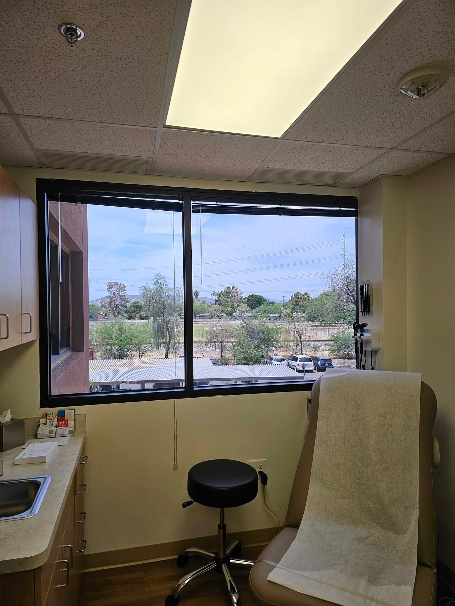 A doctor 's office with a large window and a chair