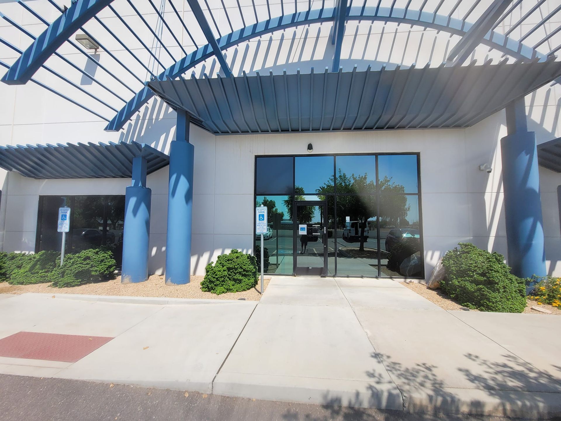 A white building with a blue awning over the entrance