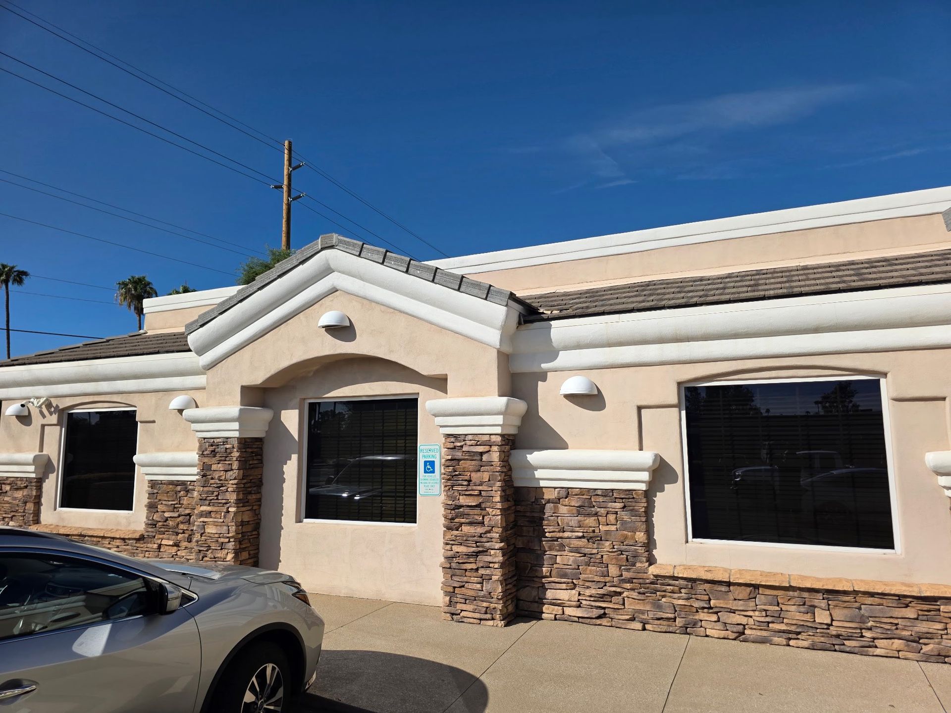 A living room with a couch , television , and chandelier.