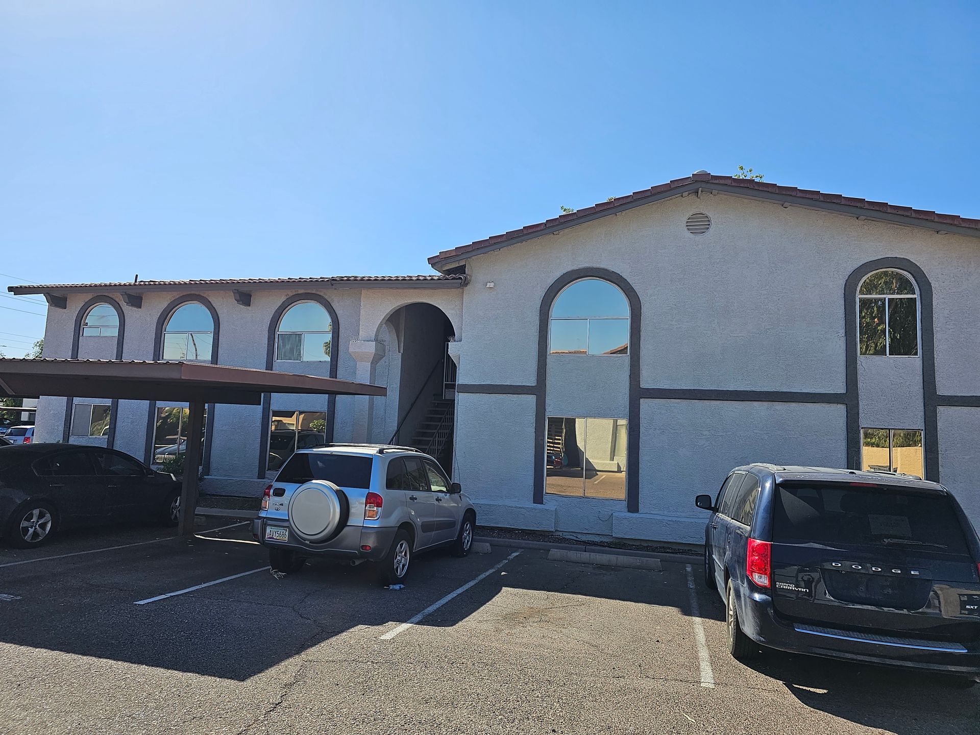 A white building with cars parked in front of it.