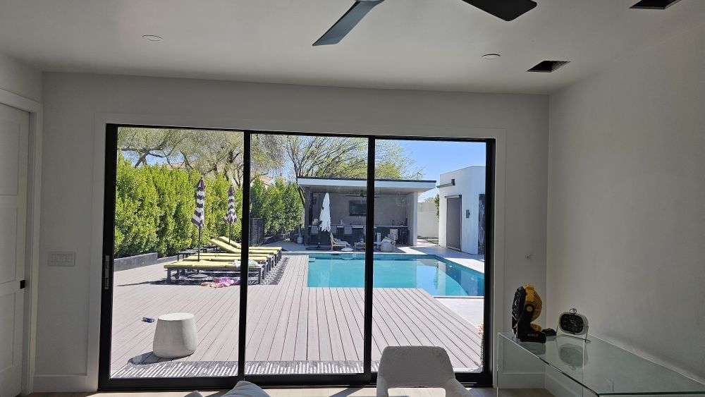 A living room with a sliding glass door leading to a pool.