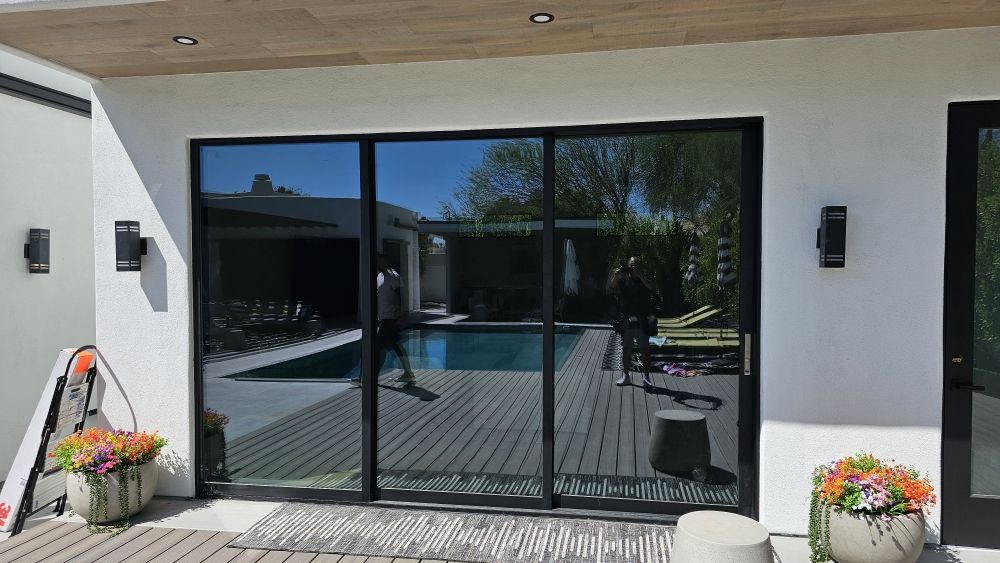 A large sliding glass door leading to a swimming pool.