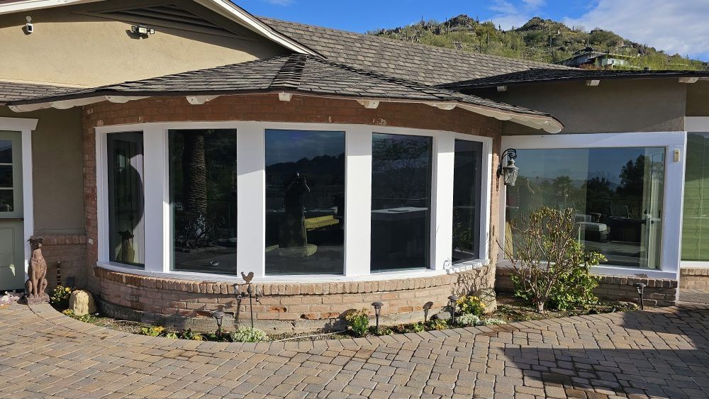 A house with a lot of windows and a brick driveway