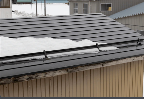 There is snow on the roof of a building.