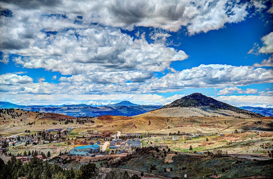 A view of a valley with mountains in the background and clouds in the sky.
