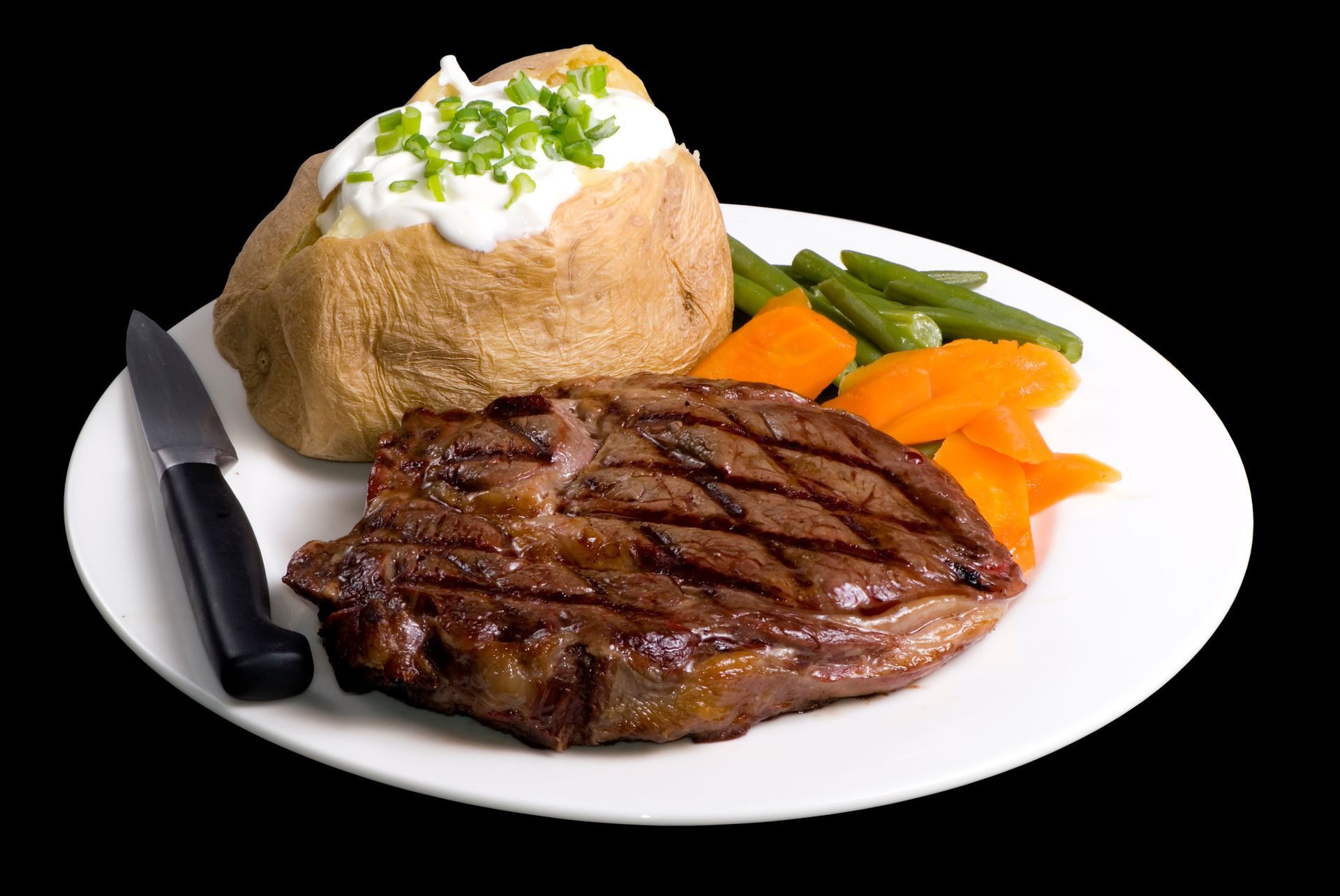 A white plate topped with a steak vegetables and a baked potato
