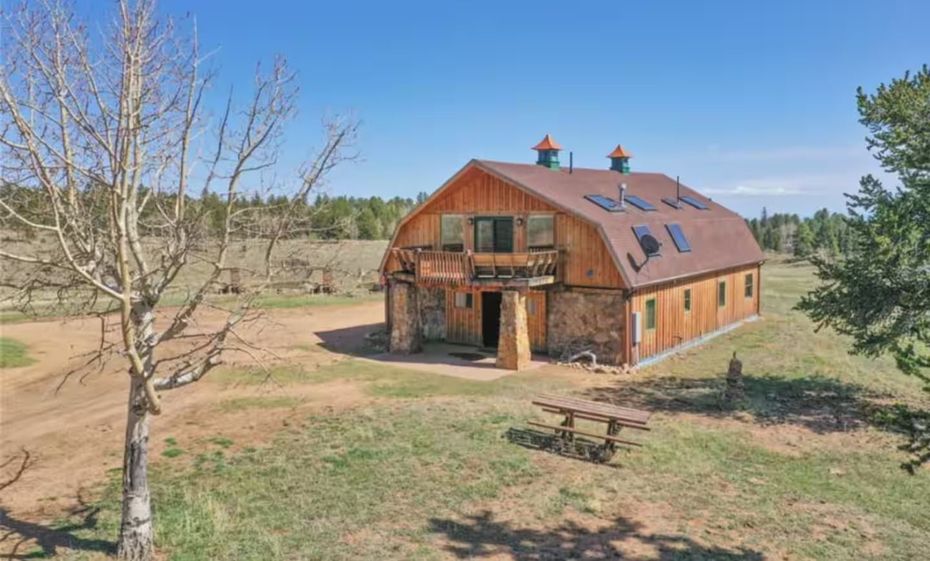 An aerial view of a barn in the middle of a grassy field.