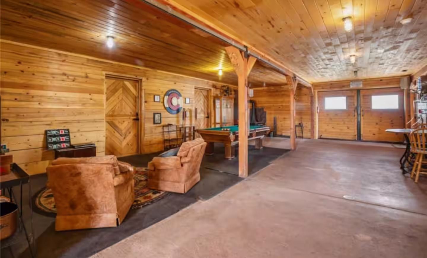 A large room with a pool table and chairs in it.
