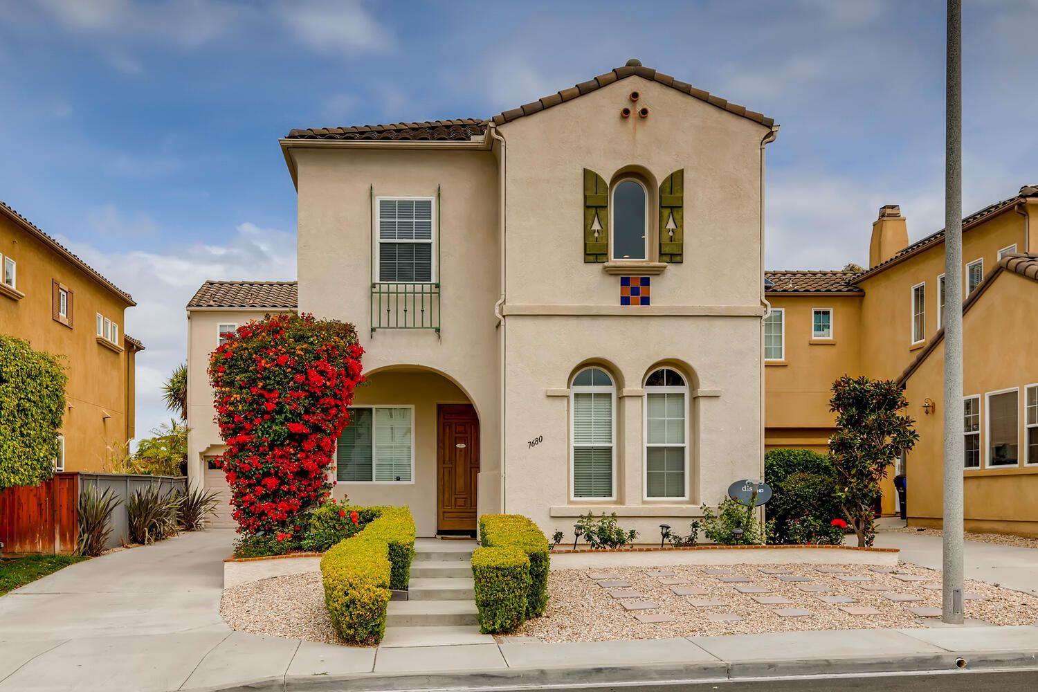 A house with a lot of windows and flowers in front of it