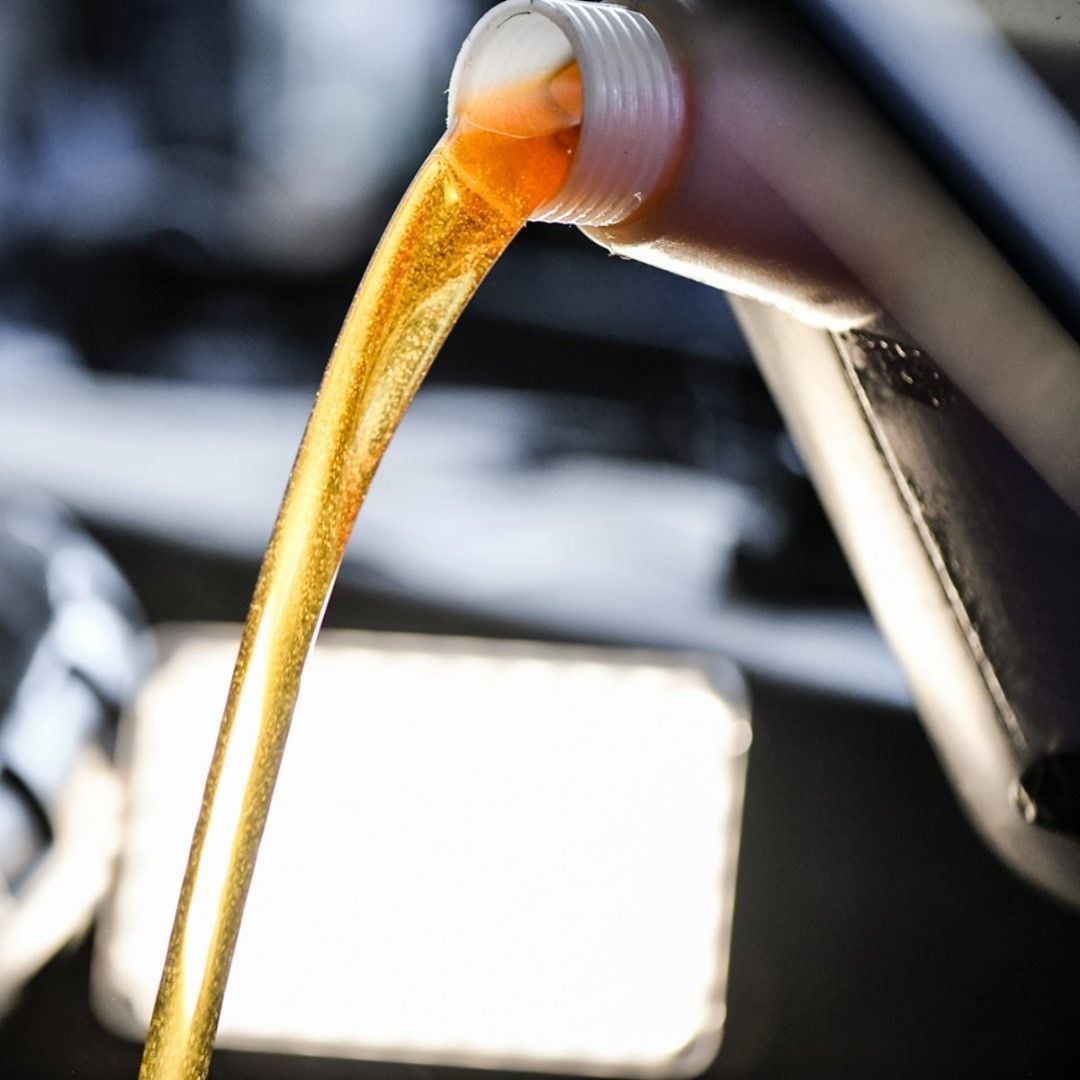 A Bottle Of Oil Being Poured Into A Car — Wilbraham, MA — Ken’s Automotive