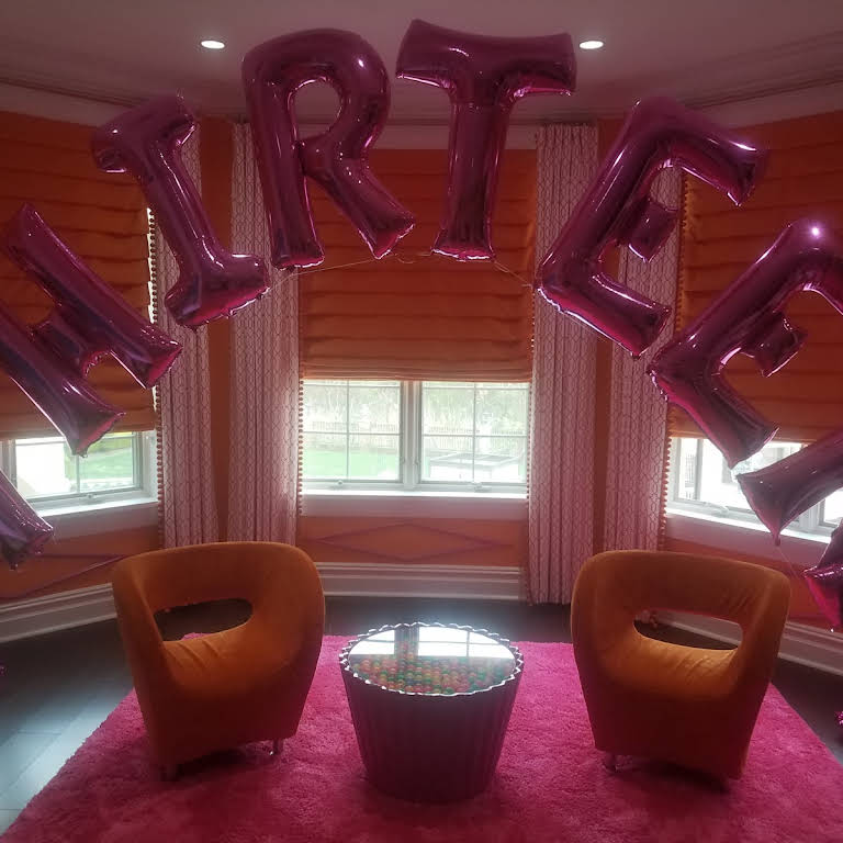 A room with chairs and balloons that spell out the word rte