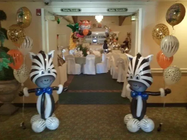Two zebras made out of balloons are standing in a hallway