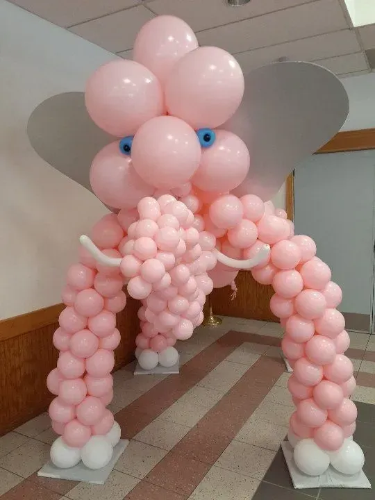 Two elephants made out of pink balloons in a hallway