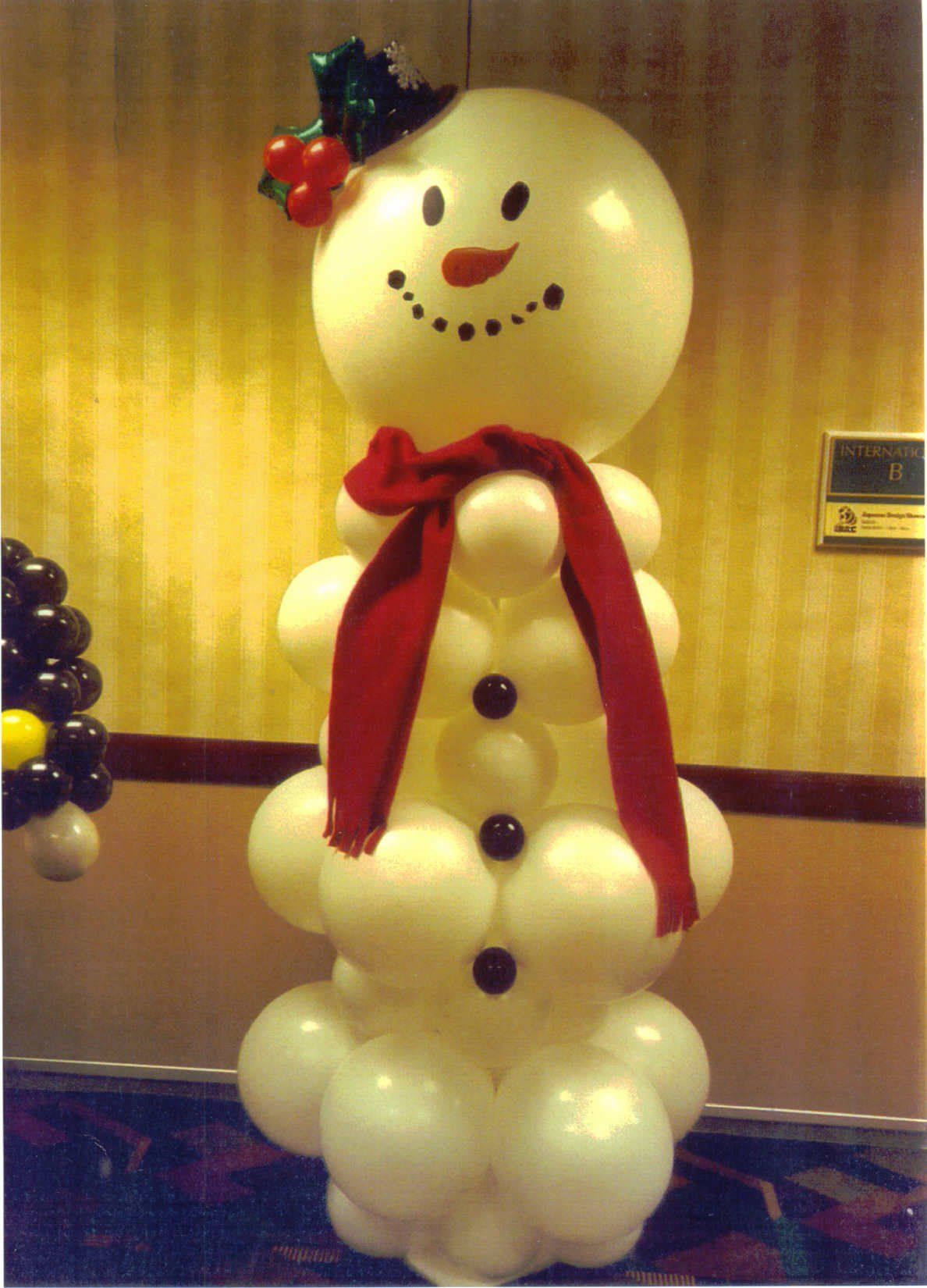 A snowman made out of balloons with a red scarf around his neck