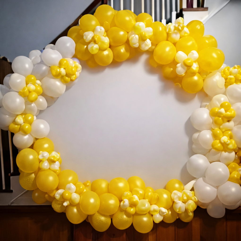 Yellow and white balloon arch shaped like a circle.