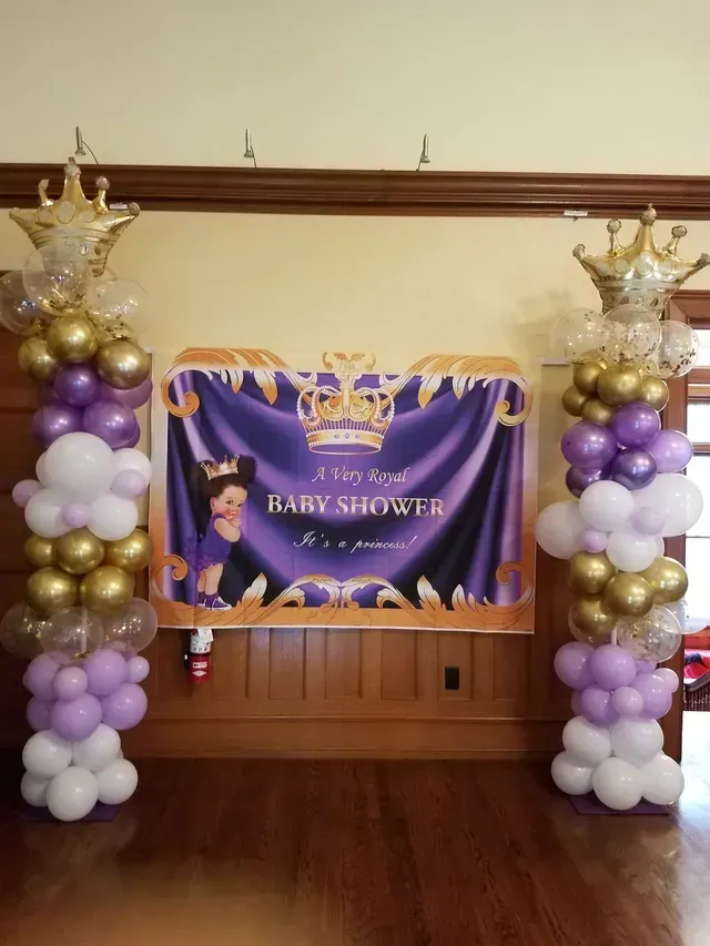 A room filled with balloons and a banner for a baby shower.