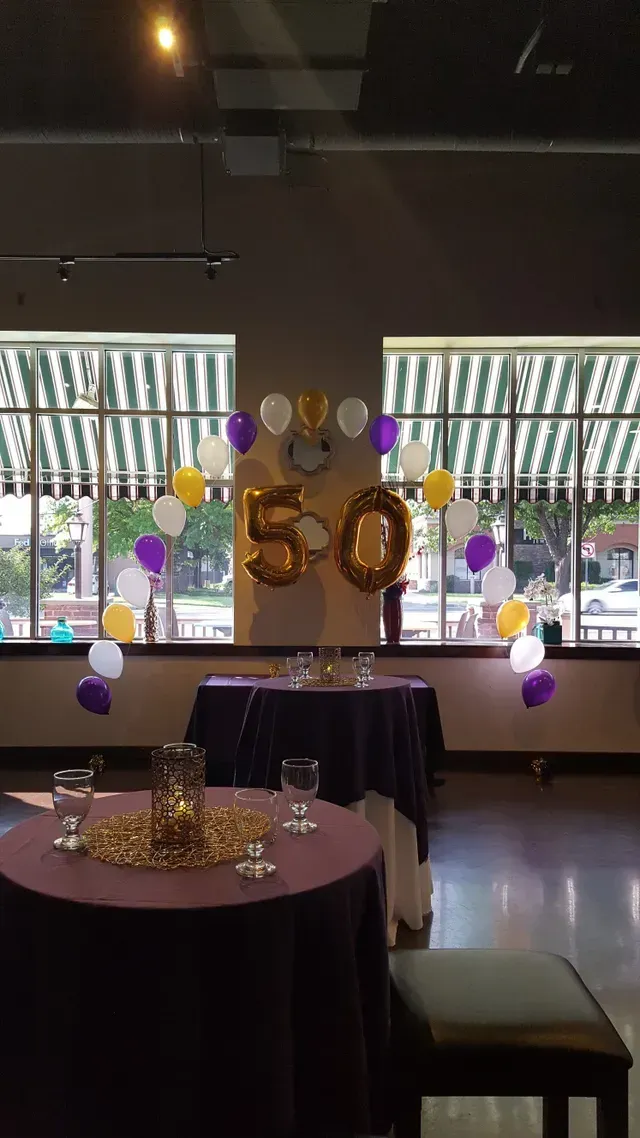 A room with tables and balloons that say 50