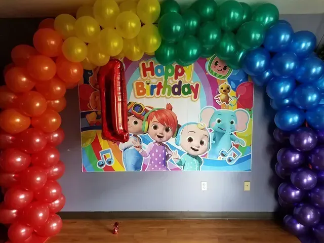 A room decorated with balloons for a child 's birthday.