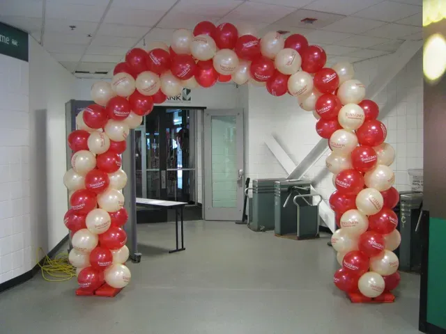 A red and white balloon arch in a hallway