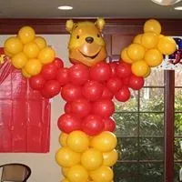 A balloon sculpture of winnie the pooh made of red and yellow balloons.
