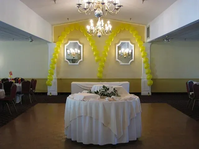 There is a table with a white tablecloth in the middle of the room.