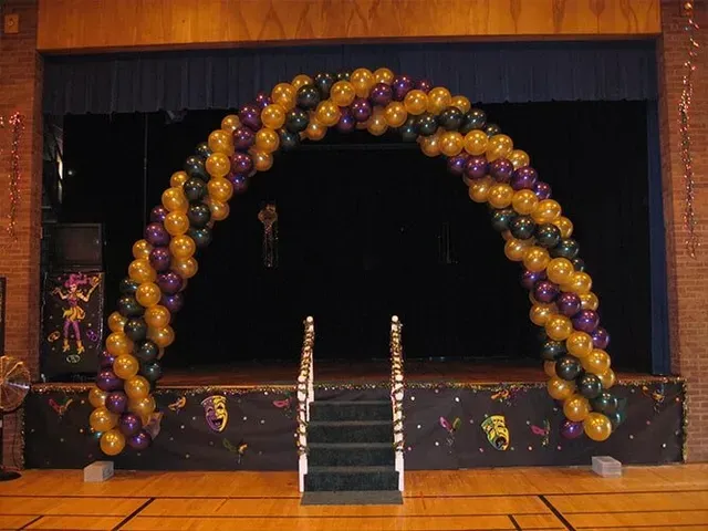 A stage decorated with balloons and masks for mardi gras
