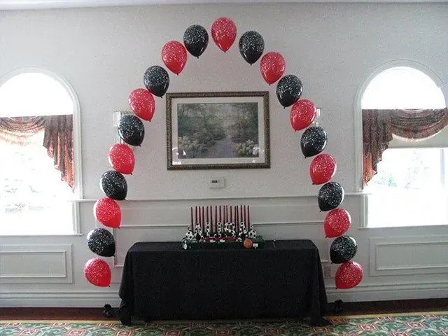 A room decorated with red and black balloons and candles