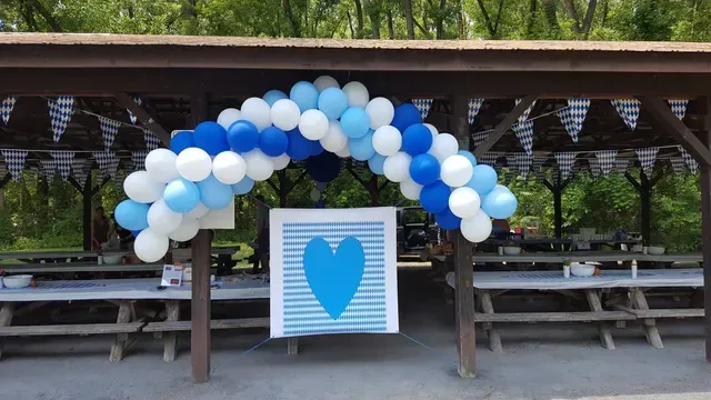 A blue and white balloon arch with a heart in the middle