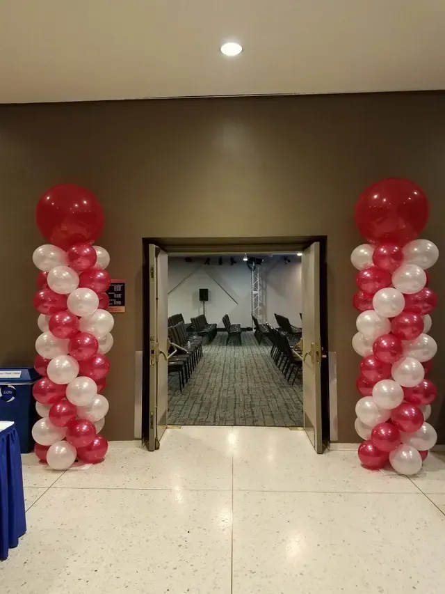 A hallway with red and white balloons in it