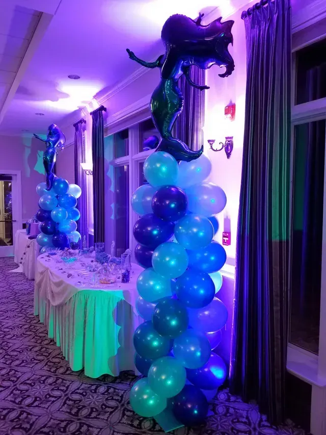 A room filled with balloons and a mermaid balloon.