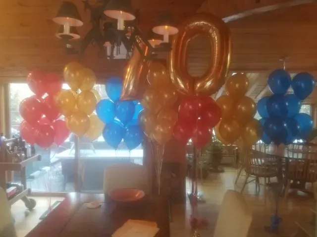 A bunch of balloons are sitting on a table in a room.