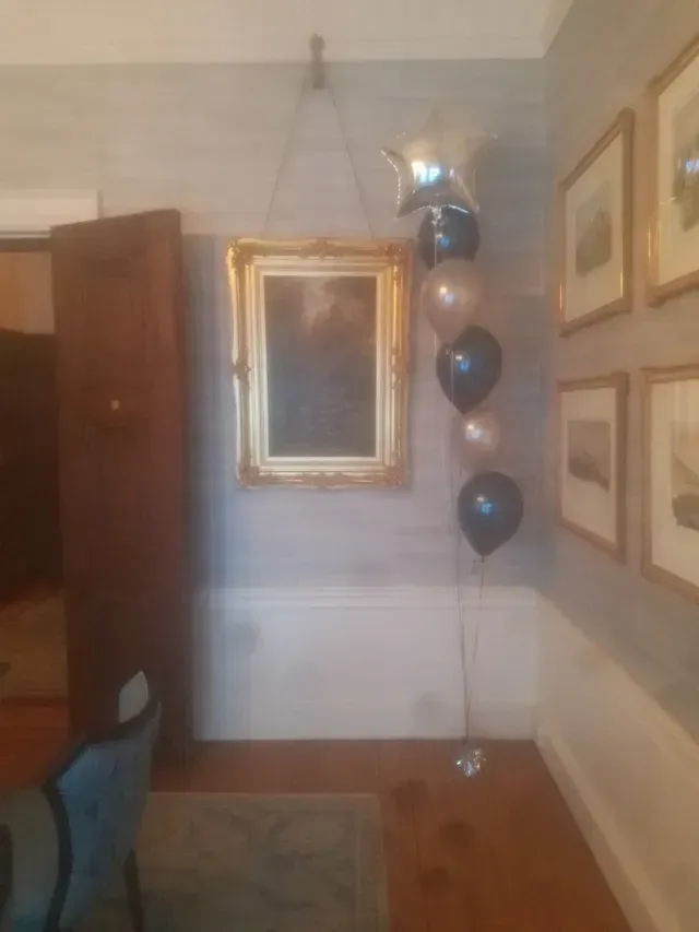 A room with a mirror and balloons on the wall