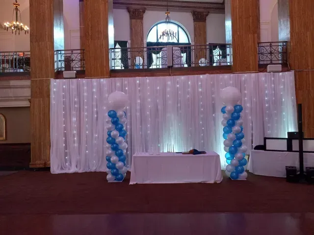 A room with blue and white balloons and a table
