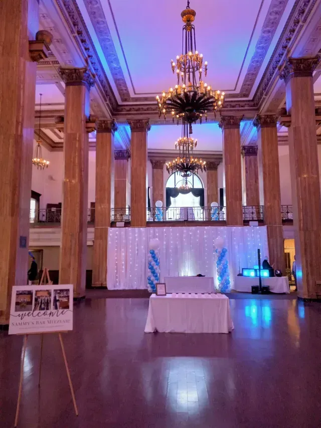A large room with columns and a table in the middle