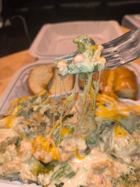 A close up of a fork holding a piece of food.