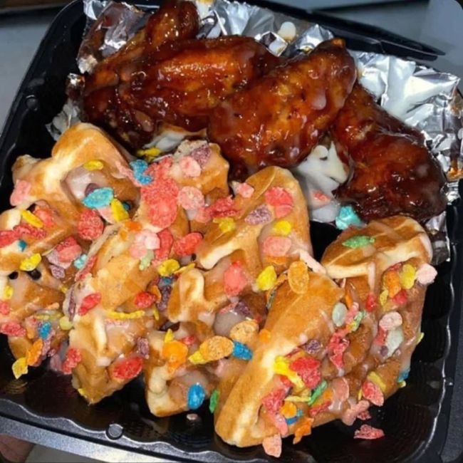 A tray of food with cereal sprinkles and chicken wings