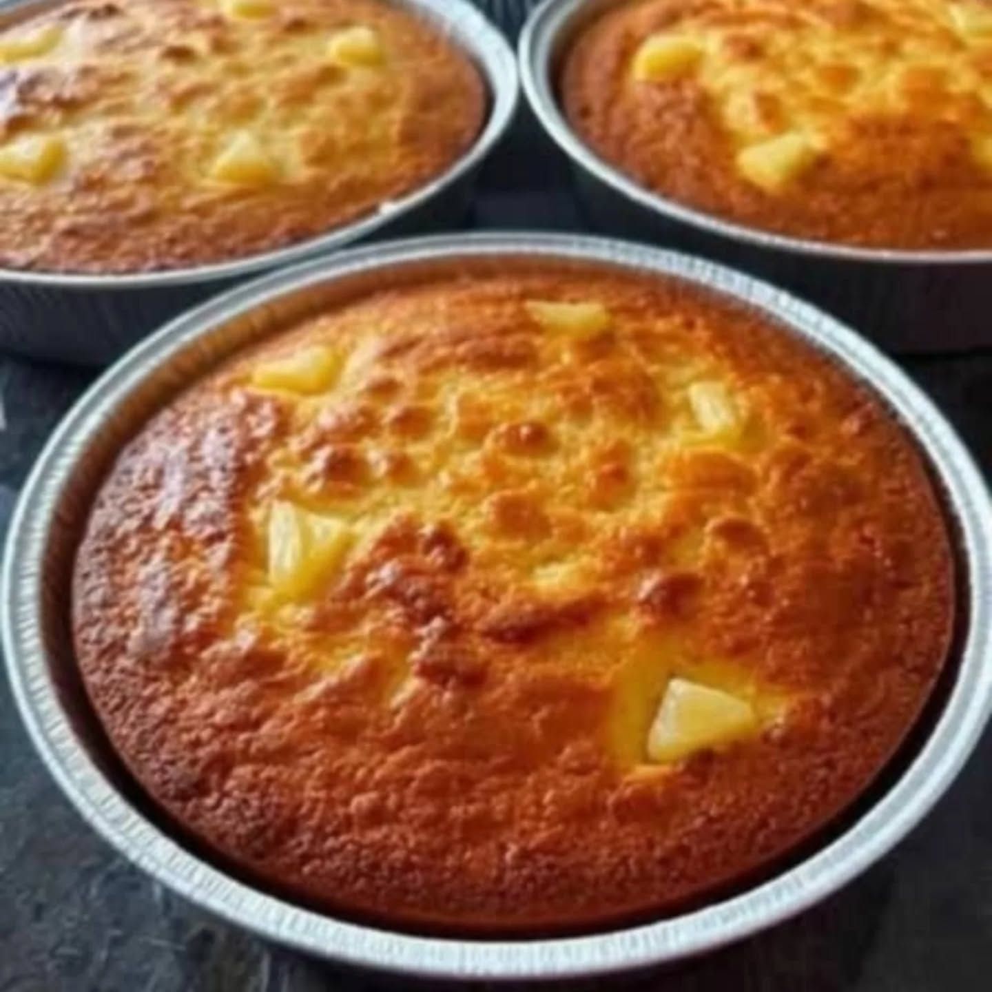 Three pans of pineapple cakes are sitting on a table.